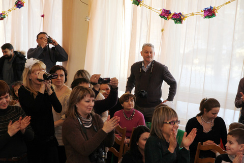 Родители аплодируют своим детишкам, выступающим на новогоднем отчетном концерте 